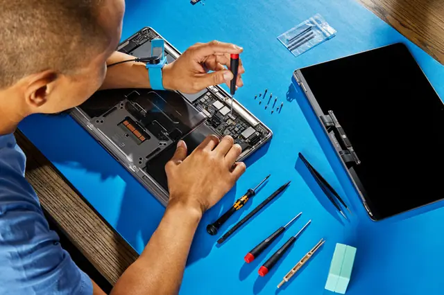 Technician repairing a MacBook at American Tech